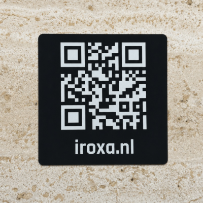 Zwart metalen QR-code bordje met witte gravure en iroxa.nl, geschikt als scanbaar tafelbordje of informatieplaatje